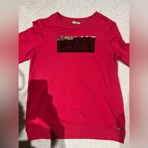 Calvin Klein on front of shirt w/shimmer of red.  Size S, worn twice.